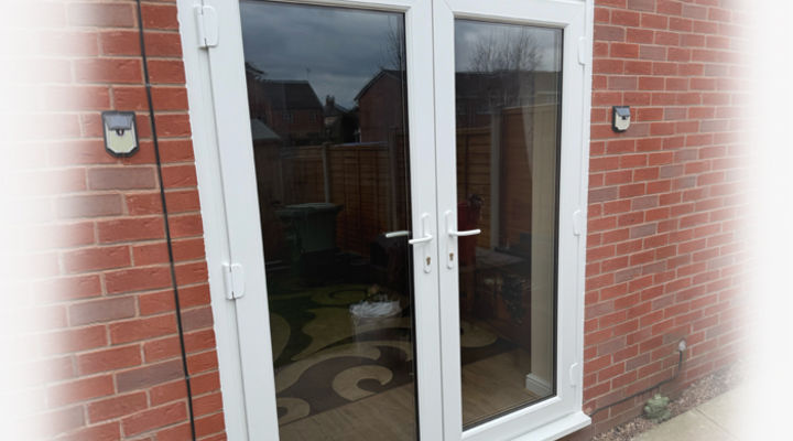 White Fully Glazed UPVC French Doors in a red bricked house