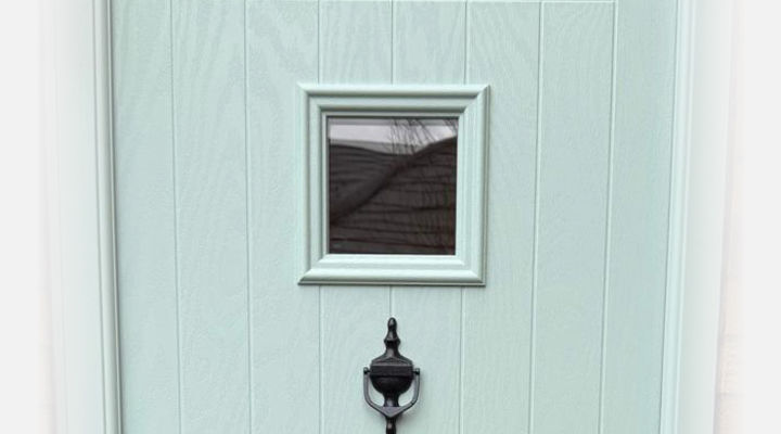 Close-up of duck egg blue cottage style composite door with black urn knocker