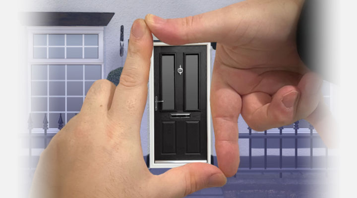 Hands framing a black composite door against a house