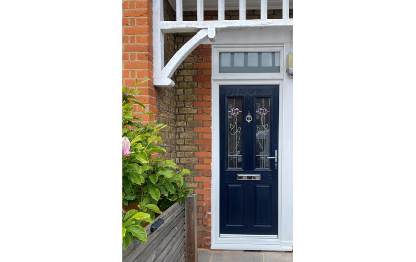 A blue composite front door with floral glass design, set within an Edwardian style home